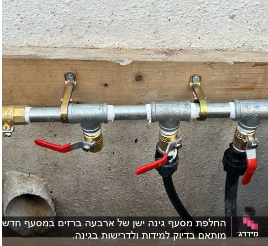 צנרת עם ברזים אדומים על קיר עץ